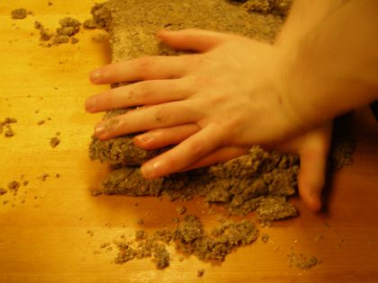 My two hands pressing down on a piece of dough.