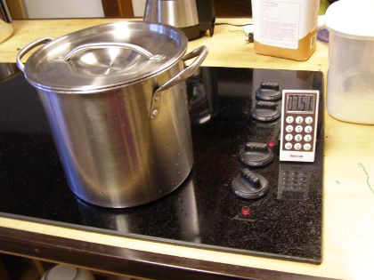 The pot of beans sits on a stove, which has been turned on. A nearby timer reads '7:51'.