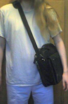 A picture of me carrying a laptop case with a single shoulder strap over my right shoulder, with the case at my left side.